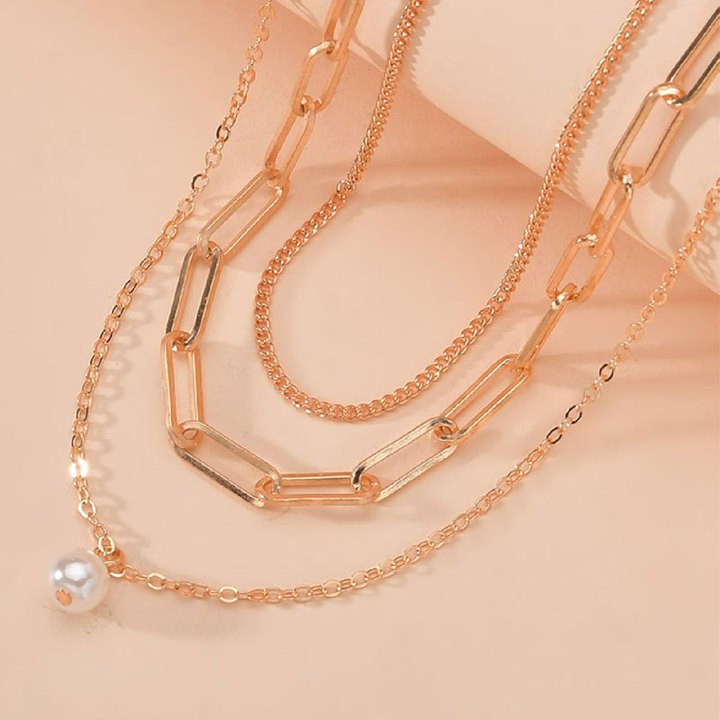"Golden Whispers: Multi-layered pendant with a delicate pearl touch